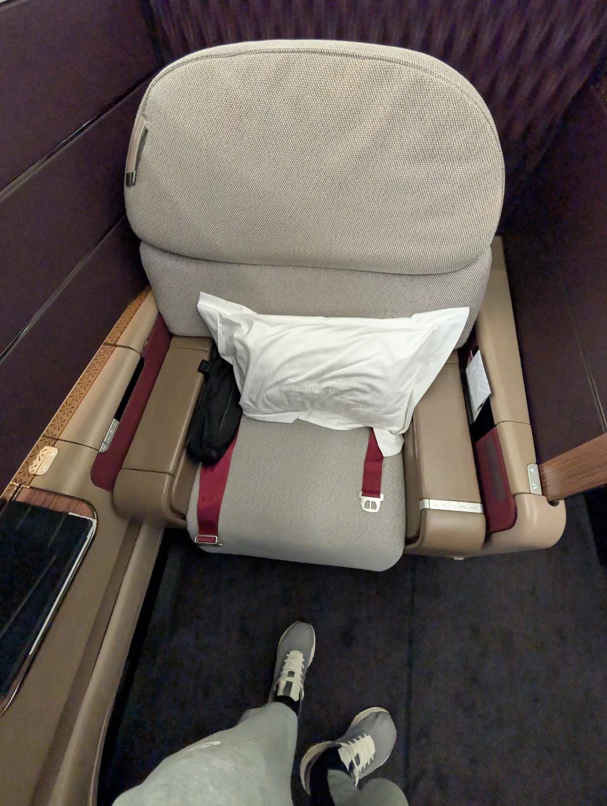 Qatar Airways First Class seat converted into a lie-flat bed with footwell view