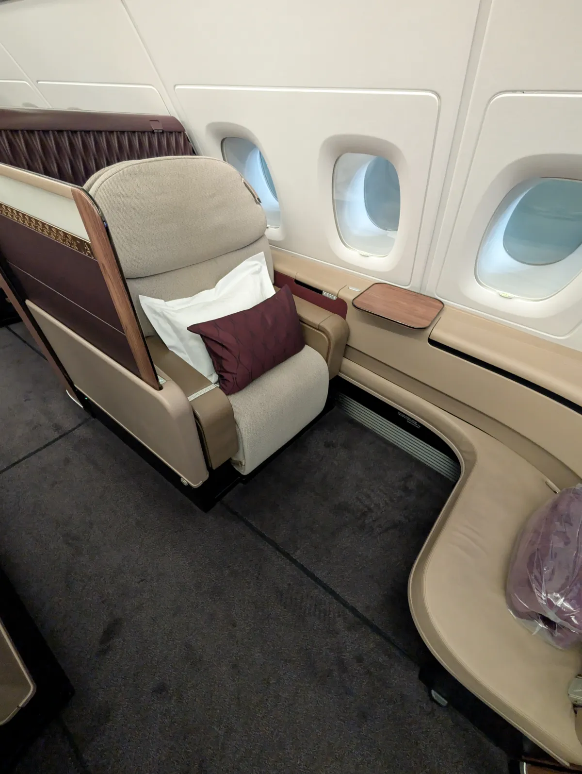 Qatar Airways First Class seat headrest with pillow next to the cabin window
