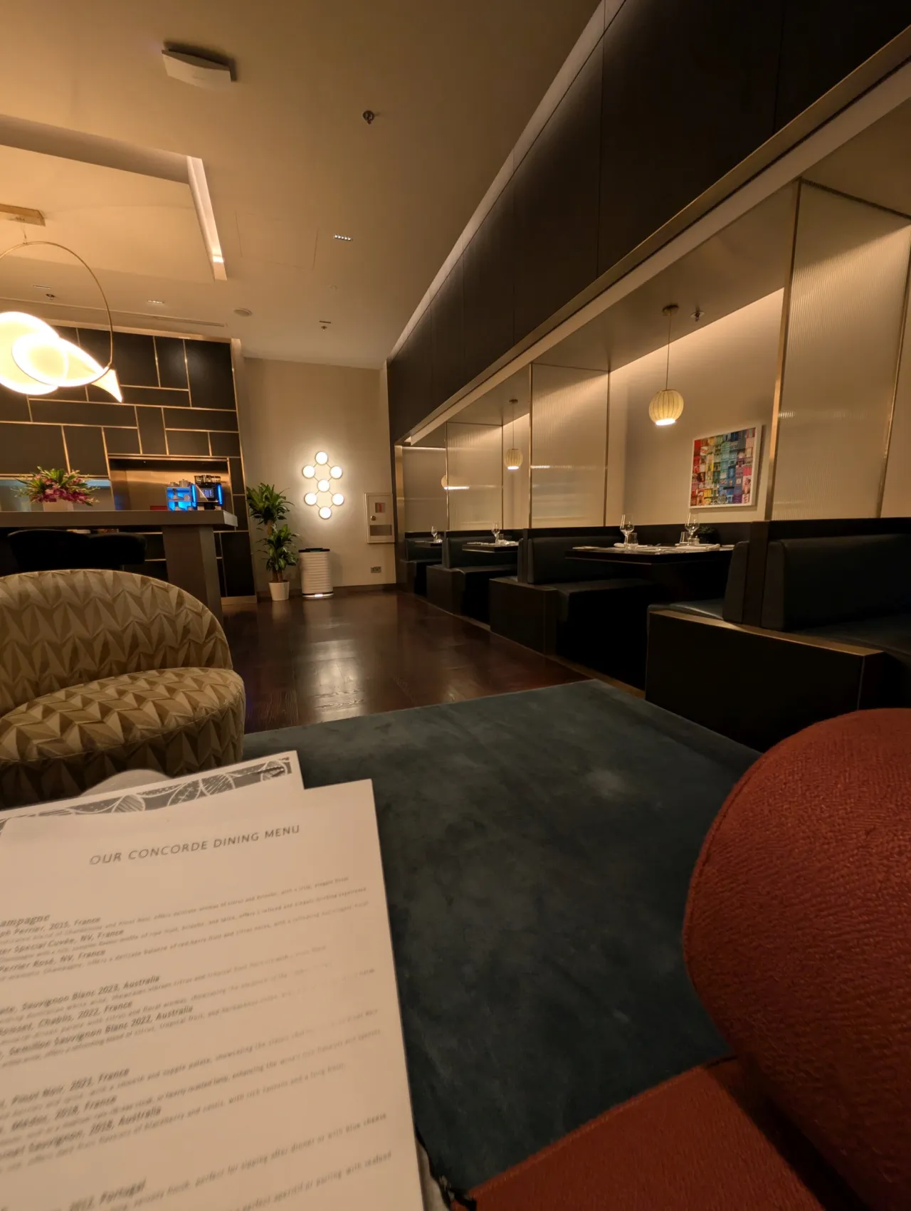 The refreshed British Airways lounge interior at Changi Terminal 1, showing the Concorde Dining booths and the drinks menu